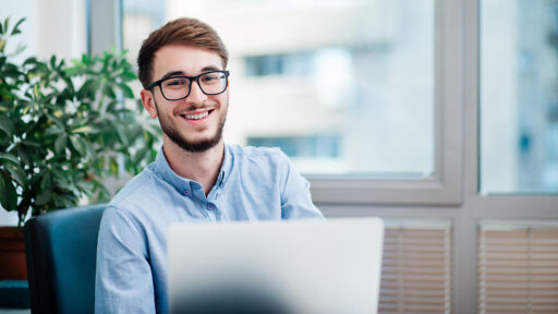 BWL Studium – Student lächelt vor Laptop BWL Studium – Student lächelt vor Laptop