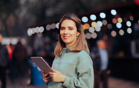 Eventmanagement Studium – Frau mit Tablet und Headset lächelt Eventmanagement Studium – Frau mit Tablet und Headset laechelt