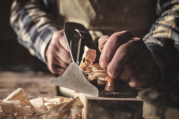 Zimmerer schleift Holz