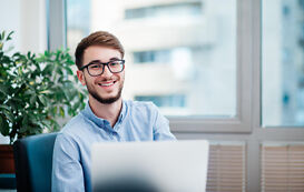 Duales Studium BWL – Student lächelt vor Laptop Duales Studium BWL – Student lächelt vor Laptop