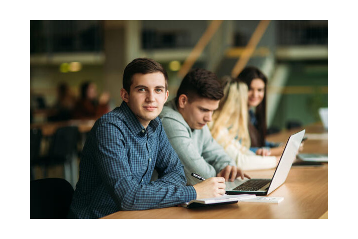 Student schreibt die Quellenangabe seiner Hausarbeit