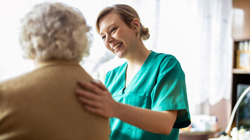 Pflegehelferin interagiert mit Seniorin Pflegehelferin interagiert mit Seniorin